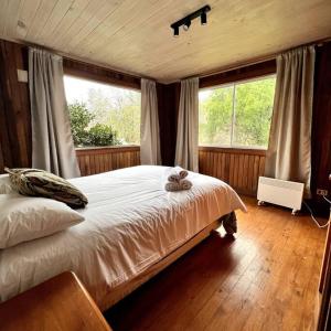 um quarto com uma cama com um urso de peluche em Casa de Campo en Caburgua, Pucón em Pucón