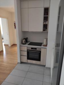 a kitchen with white cabinets and a stove top oven at Belgrade Waterfront Comfortable Apartment in Belgrade