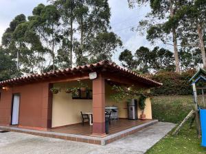 ein kleines Haus mit einer Holzterrasse mit einem Tisch in der Unterkunft Cottage Refuge in Rionegro