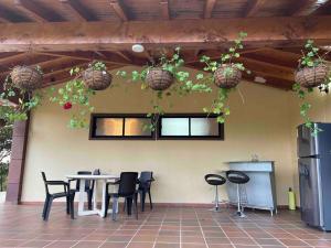 eine Terrasse mit Tisch, Stühlen und Pflanzen in der Unterkunft Cottage Refuge in Rionegro