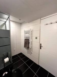 a white bathroom with a shower and a towel at La Cosy Green Suite in Colombelles