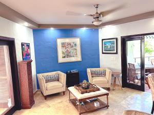 a living room with two chairs and a blue wall at Come, Enjoy & Relax at Rio Mar Cluster II, Rio Grande, PR in Rio Grande