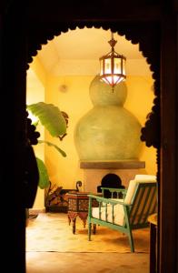 um quarto com uma lareira, uma mesa e uma luz em RIAD DAR NAOMI em Marrakech