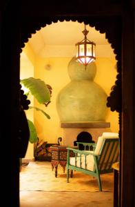 a room with a fireplace and a table and a light at RIAD DAR NAOMI in Marrakech