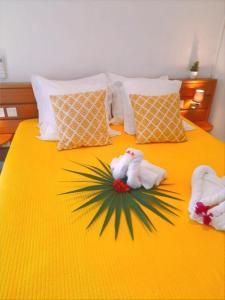 łóżko z dwoma ręcznikami i palmą w obiekcie F3 _ Kaz ananas passion au Manganao w mieście Saint-François