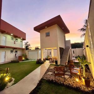 a house with a patio and a lawn at Residencial 220 Maresias in Maresias