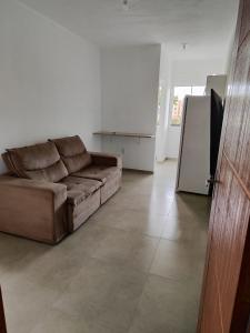 a living room with a brown couch and a refrigerator at Apartamento de 1 quarto próximo a 101 in Itajaí