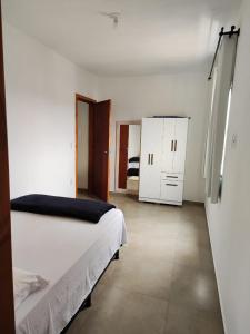 a bedroom with a white bed and a white cabinet at Apartamento de 1 quarto próximo a 101 in Itajaí