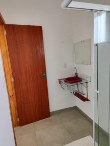 a bathroom with a red sink and a glass door at Apartamento de 1 quarto próximo a 101 in Itajaí