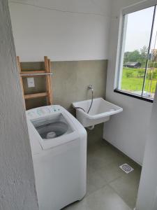 a white bathroom with a toilet and a sink at Apartamento de 1 quarto próximo a 101 in Itajaí