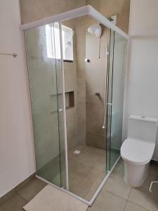 a bathroom with a glass shower with a toilet at Apartamento de 1 quarto próximo a 101 in Itajaí