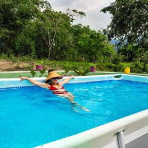 a man in a swimming pool with a hat at El Cielo Biohospedaje in Tena