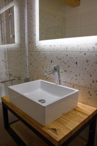 lavabo blanco en una mesa de madera en el baño en Penzion pod Hazmburkem, 