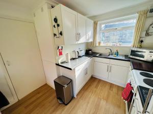 uma cozinha com armários brancos e um lavatório em 2 Bedroom Chalet SB177 Sandown Isle of Wight em Brading