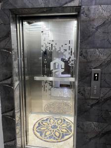 a glass elevator in a bathroom with a tile floor at Travellers Heaven 3BR APT DHA PHASE VI in Karachi