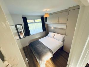 um pequeno quarto com uma cama e uma janela em 2 Bedroom Chalet SB177 Sandown Isle of Wight em Brading