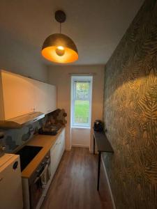 uma cozinha com uma mesa e uma janela em The Wee Studio Flat em Paisley
