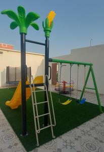 un parque infantil con escalera y columpio en استراحة الأولين en Yeda