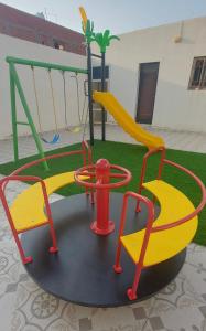 un parque infantil con tobogán y columpio en استراحة الأولين, en Yeda