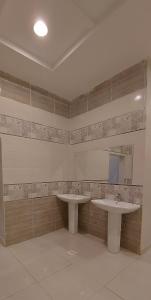 ein Badezimmer mit 2 Waschbecken und einem Spiegel in der Unterkunft استراحة الأولين in Dschidda