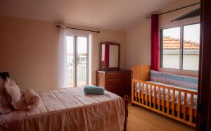 a baby bedroom with a crib and a window at The House of Passos in Ponta do Sol