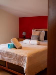 a bedroom with a large bed with a red wall at The House of Passos in Ponta do Sol