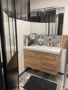 La salle de bains est pourvue d'un lavabo et d'un miroir. dans l'établissement Jolie villa à Grasse quartier Saint Antoine, à Grasse