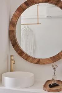 a bathroom with a round mirror above a sink at The Brunswick, Brunswick Heads in Brunswick Heads