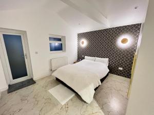 1 dormitorio con cama y pared en Cozy Luxury Private Cottage en Greenford