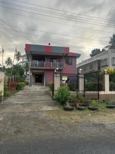 a pink house with a fence in front of it at Karans Apartment in Varoka