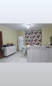 a kitchen with white appliances and a refrigerator at Sítio casa grande in São Gonçalo do Amarante