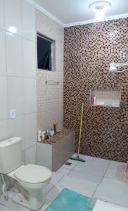 a bathroom with a toilet and a brick wall at Sítio casa grande in São Gonçalo do Amarante