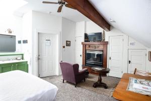 a bedroom with a bed and a chair and a fireplace at Walnut Street Inn in Springfield