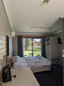 a bedroom with a bed and a large window at Boomerang Way Tourist Park in Tocumwal