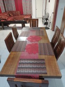 einem Tisch mit vier Stühlen und einem Tisch mit Matten darauf in der Unterkunft Ilob Transient House in Banaue