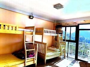 3 Etagenbetten in einem Zimmer mit Balkon in der Unterkunft Ilob Transient House in Banaue