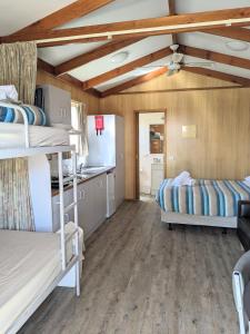 a room with two bunk beds and a kitchen at Boomerang Way Tourist Park in Tocumwal