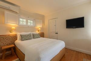 a bedroom with a bed and a flat screen tv at Quinta das Casas - Douro Winery & Villas in Vila Real