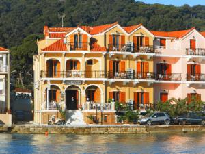 una casa en el agua con coches aparcados delante en Hotel Aggelos Kefalonia en Argostoli