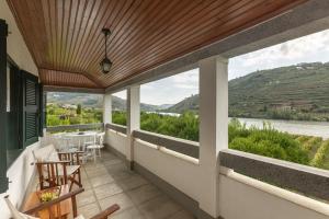 a balcony with a view of a river and mountains at Quinta das Casas - Douro Winery & Villas in Vila Real
