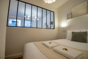 ランスにあるLa verrière Rémoiseのベッドとタオル2枚のある寝室