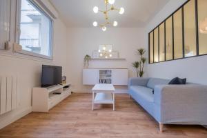 ランスにあるLa verrière Rémoiseの青いソファとテレビのあるリビングルーム