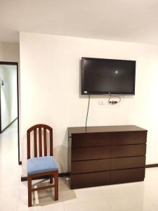 a room with a tv and a chair and a dresser at Departamento con excelente vista de la ciudad in Tarija