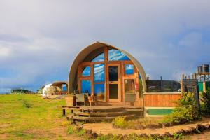 a small house with a large window on a field at Little Amanya Camp in Amboseli