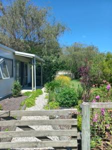 a garden with a fence and a house at One bedroom country cottage in Motueka