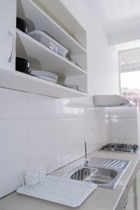 eine weiße Küche mit einer Spüle und einer Theke in der Unterkunft Suite and Business in Pucallpa