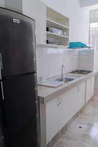 uma cozinha com um frigorífico preto e um lavatório em Suite and Business em Pucallpa