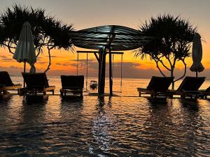 蓝梦岛Ketut Losmen Bungalows Lembongan的海滩上的一组椅子和遮阳伞