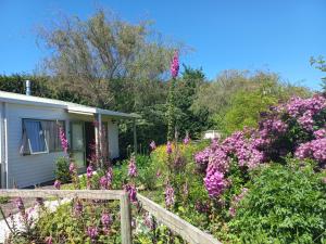 a garden of flowers in front of a house at One bedroom country cottage in Motueka
