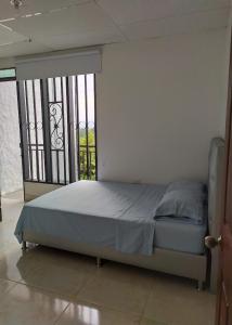 1 dormitorio con 1 cama frente a una ventana en CASA DE CAMPO LA VICTORIA en Rivera